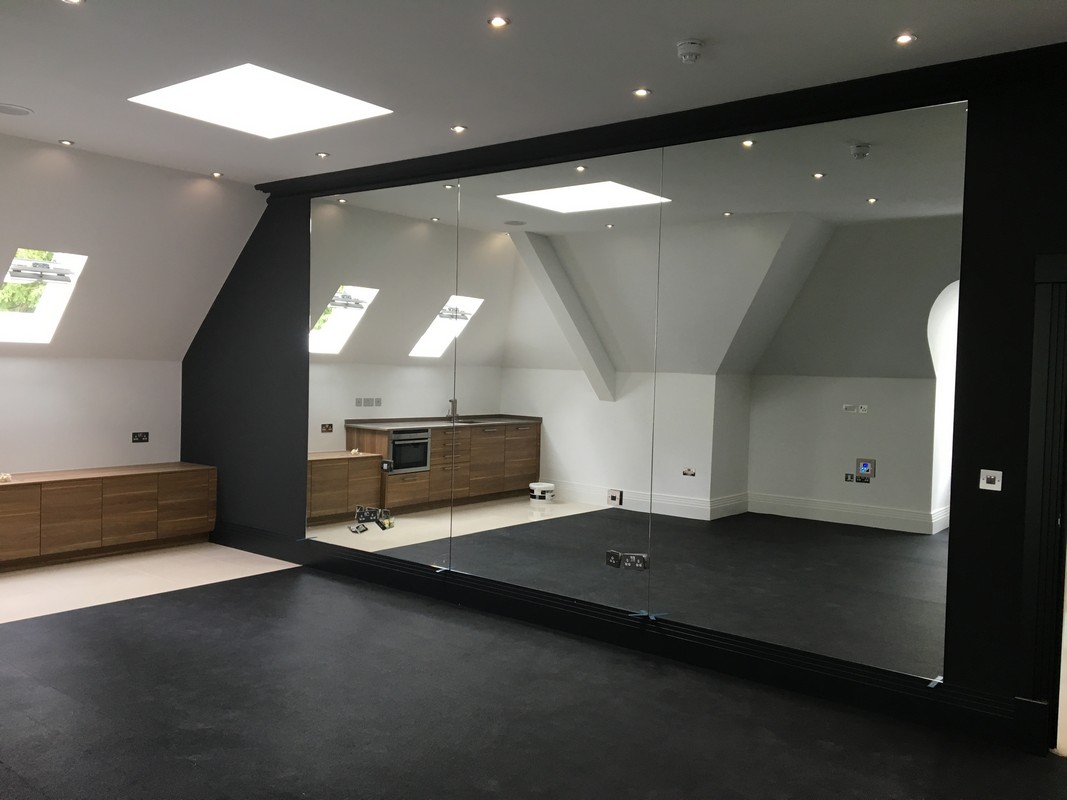 Frameless glass wall dividing loft conversion in Finchley Central